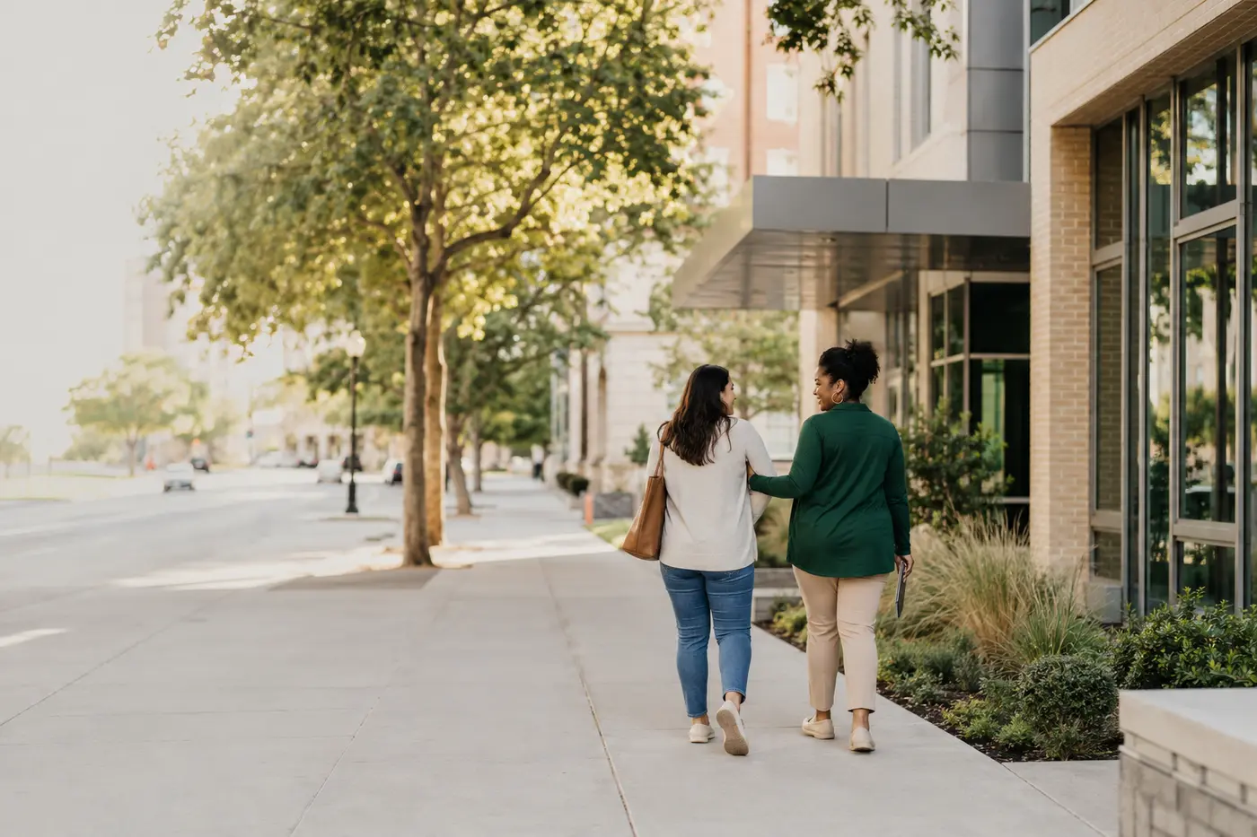 A care navigator walking with an adult near a community health center in Los Angeles